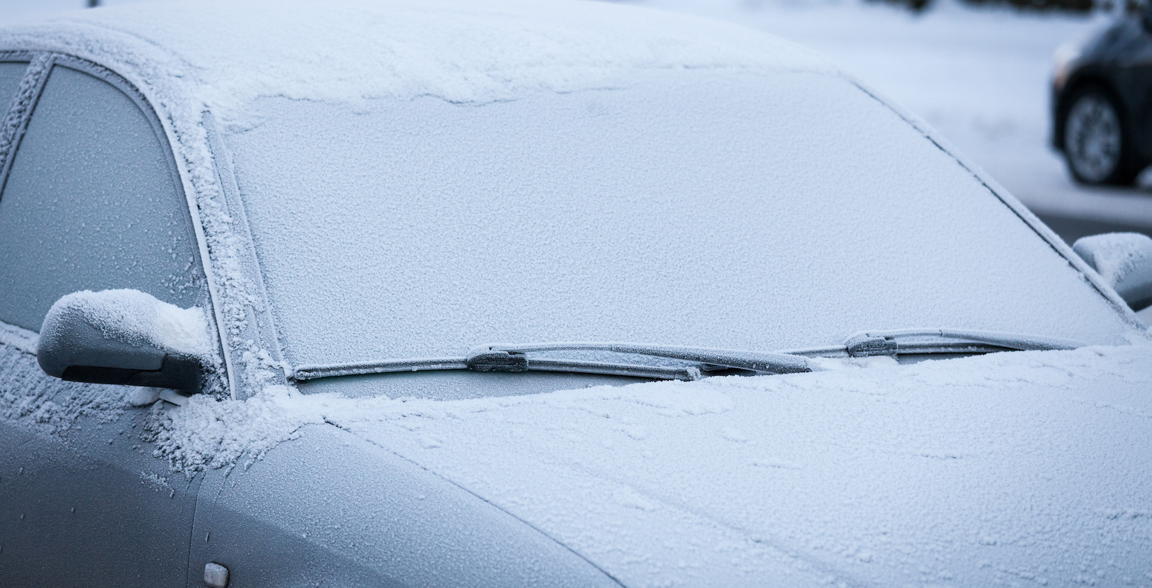Car covered with snow, with wipers off